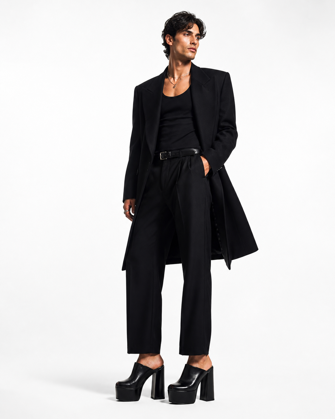 Person wearing a black suit with platform shoes on a white background