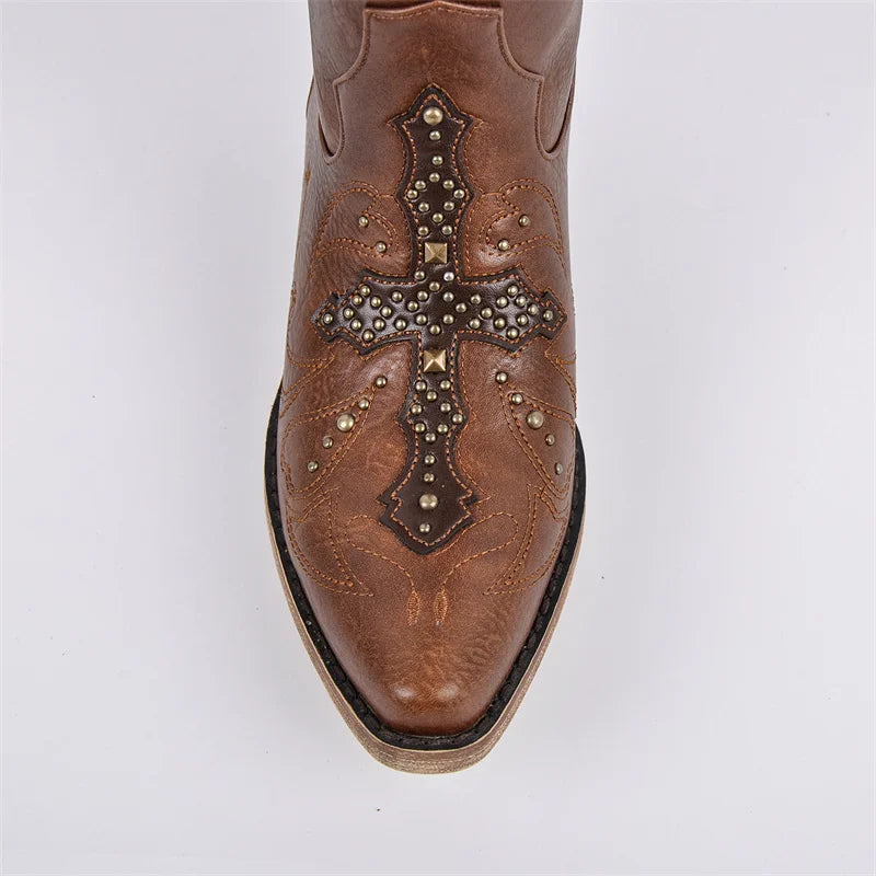 Brown cowboy boot with cross design and studs on a white background