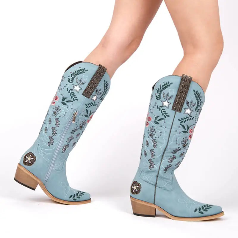 Light blue cowboy boots with floral patterns and star embellishments on a white background