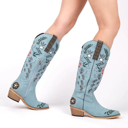 Light blue cowboy boots with floral patterns and star embellishments on a white background