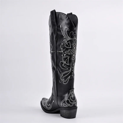 Black cowboy boot with white embroidery on a light gray background