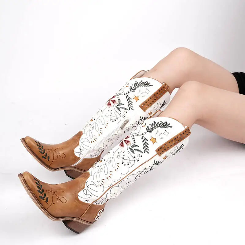 Brown and white cowboy boots with floral patterns on a white background