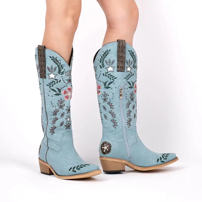 Light blue cowboy boots with floral patterns on a white background
