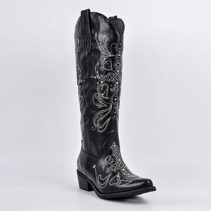 Black cowboy boot with intricate white embroidery on a light gray background