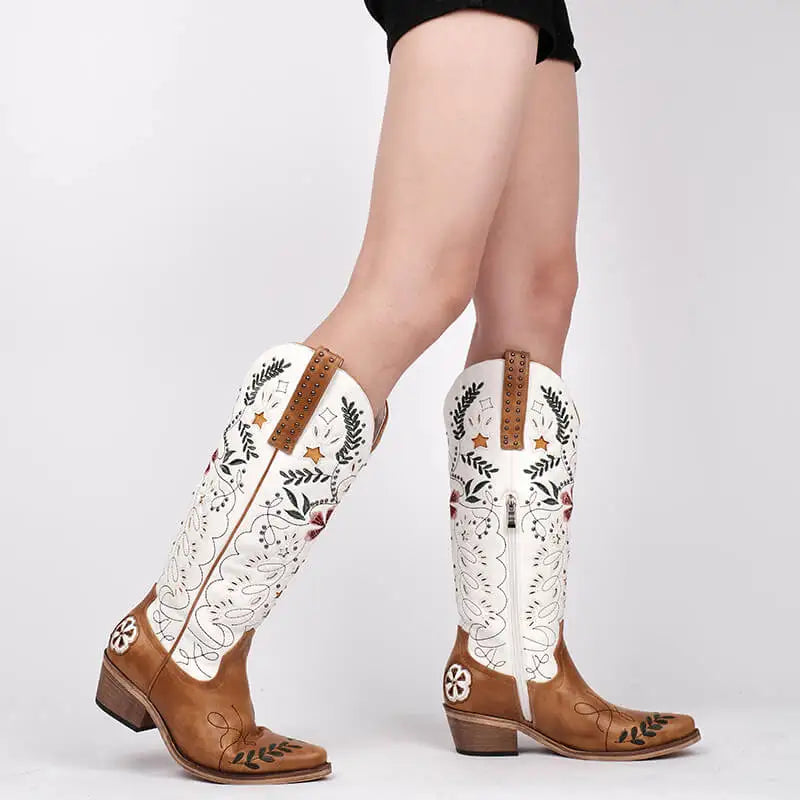 Brown and white embroidered cowboy boots on a plain background
