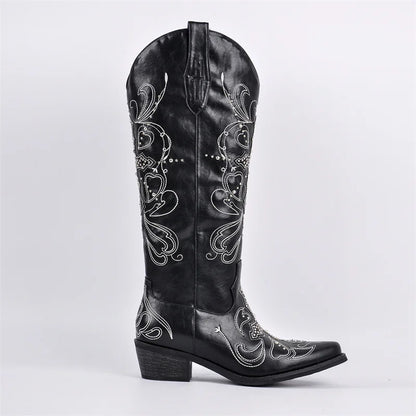 Black cowboy boot with intricate white embroidery on a light gray background