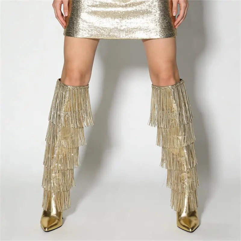 Gold fringe boots worn with a metallic skirt on a white background