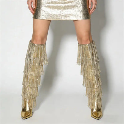 Gold fringe boots worn with a metallic skirt on a white background