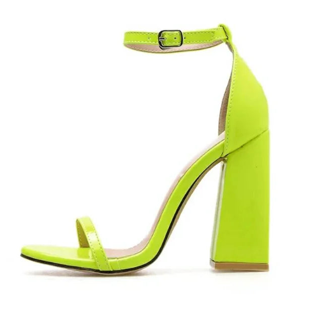 Neon green high-heeled sandal on a white background