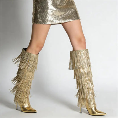 Gold fringe boots worn with a gold sequin skirt on a plain background