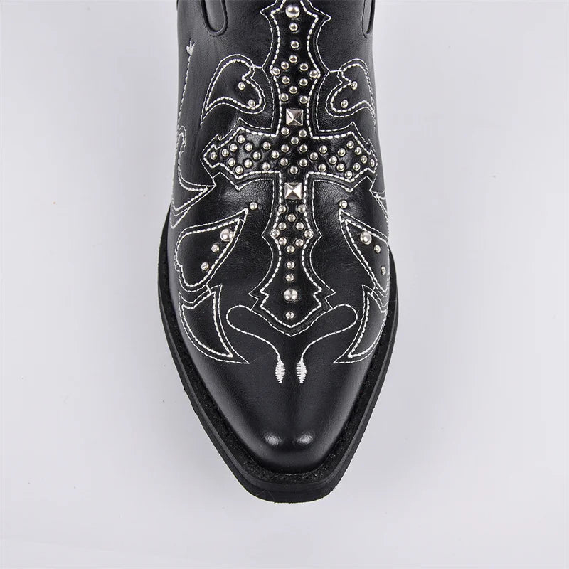 Black cowboy boot with intricate silver designs on a light gray background