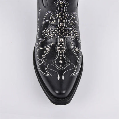 Black cowboy boot with intricate silver designs on a light gray background