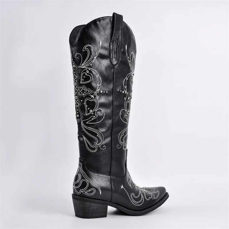 Black leather boot with intricate white embroidery on a light gray background
