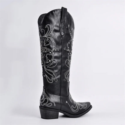 Black leather boot with intricate white embroidery on a light gray background