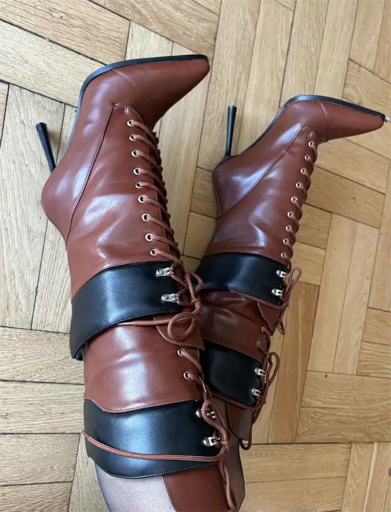 Brown leather boots with black accents on a wooden floor