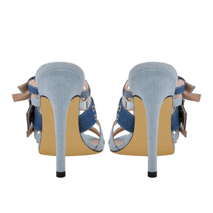 Pair of high-heeled shoes with denim straps on a white background