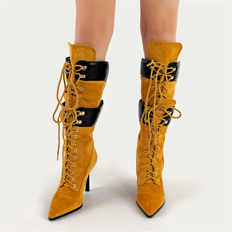 Yellow suede high-heeled boots with black accents on a white background