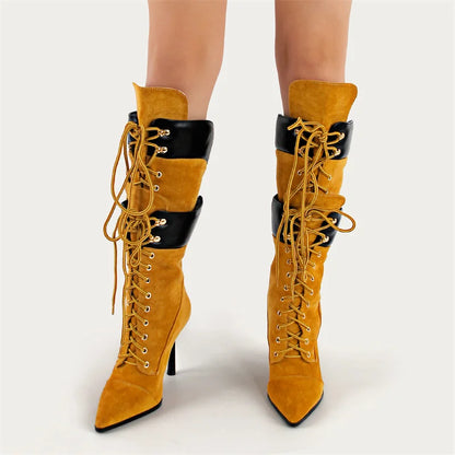 Yellow suede high-heeled boots with black accents on a white background