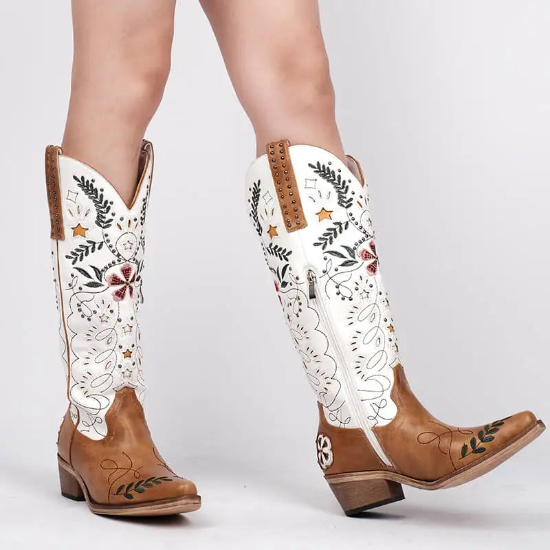 Brown and white embroidered cowboy boots on a light gray background