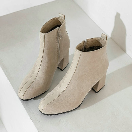 A pair of beige, pointed-toe block heel boots for men, displayed against a neutral background.