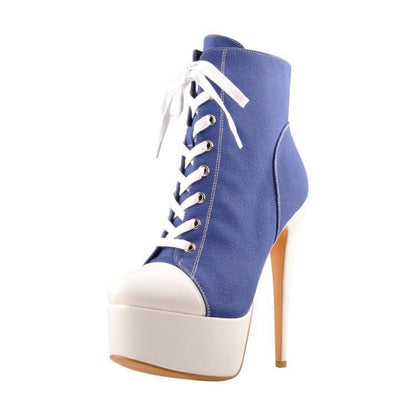 A pair of men's high heels with a lace-up closure, featuring a black leather upper, a white sole, and a stiletto heel design.